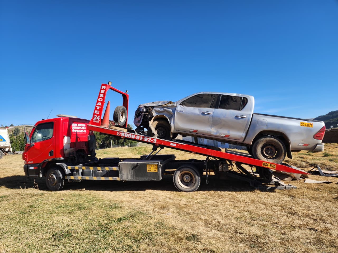 Camioneta plateada sobre la plataforma inclinada de la grúa